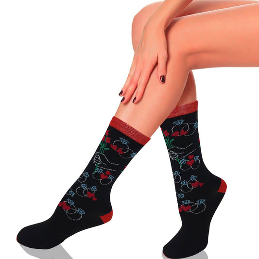 Black socks with red accents and floral patterns worn by a person on a white background